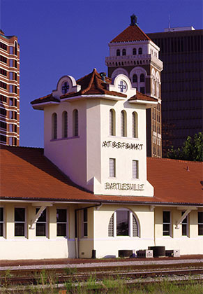 Beautiful downtown Bartlesville, Oklahoma serving as a backdrop to the historic train station that now serves as the Bartlesville Chamber of Commerce